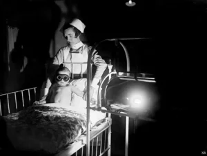 1928 photo of a nurse exposing a small child in goggles to a machine that shines line