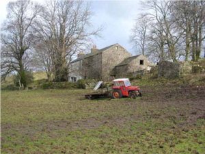 A pastoral farm with a tractor in a field and a farm house in the distance