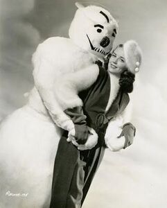 Vintage photo of a snowman with his arms around a woman's waste