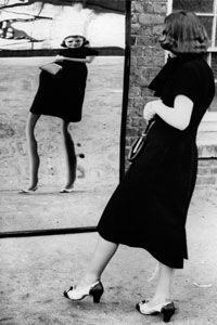 Woman looking at herself in a warped mirror