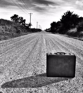 a suitcase in the middle of a country road