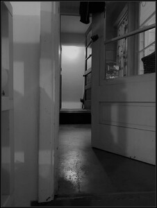 black and white photo of a door opening on to a hallway