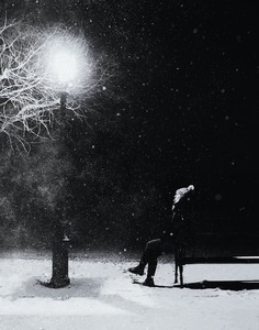 Woman sitting on a bench in the snow