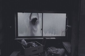 Figure standing outside looking in through a window