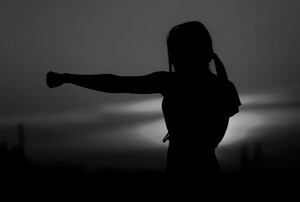 Silhouette of a woman punching