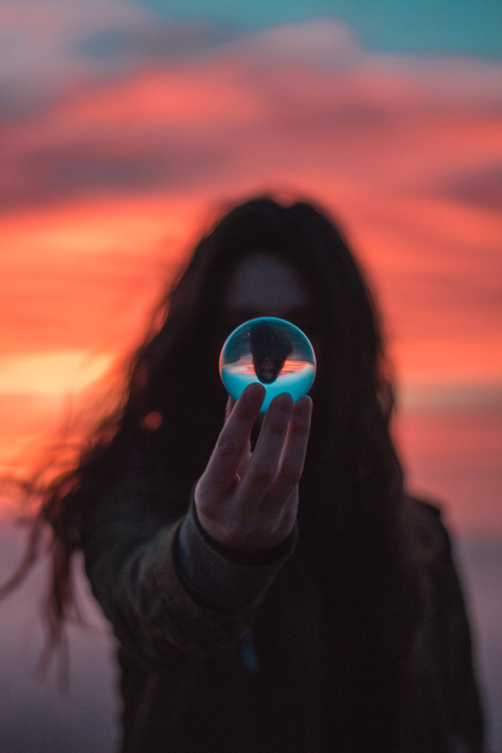 woman holding a crystal ball in front of her face
