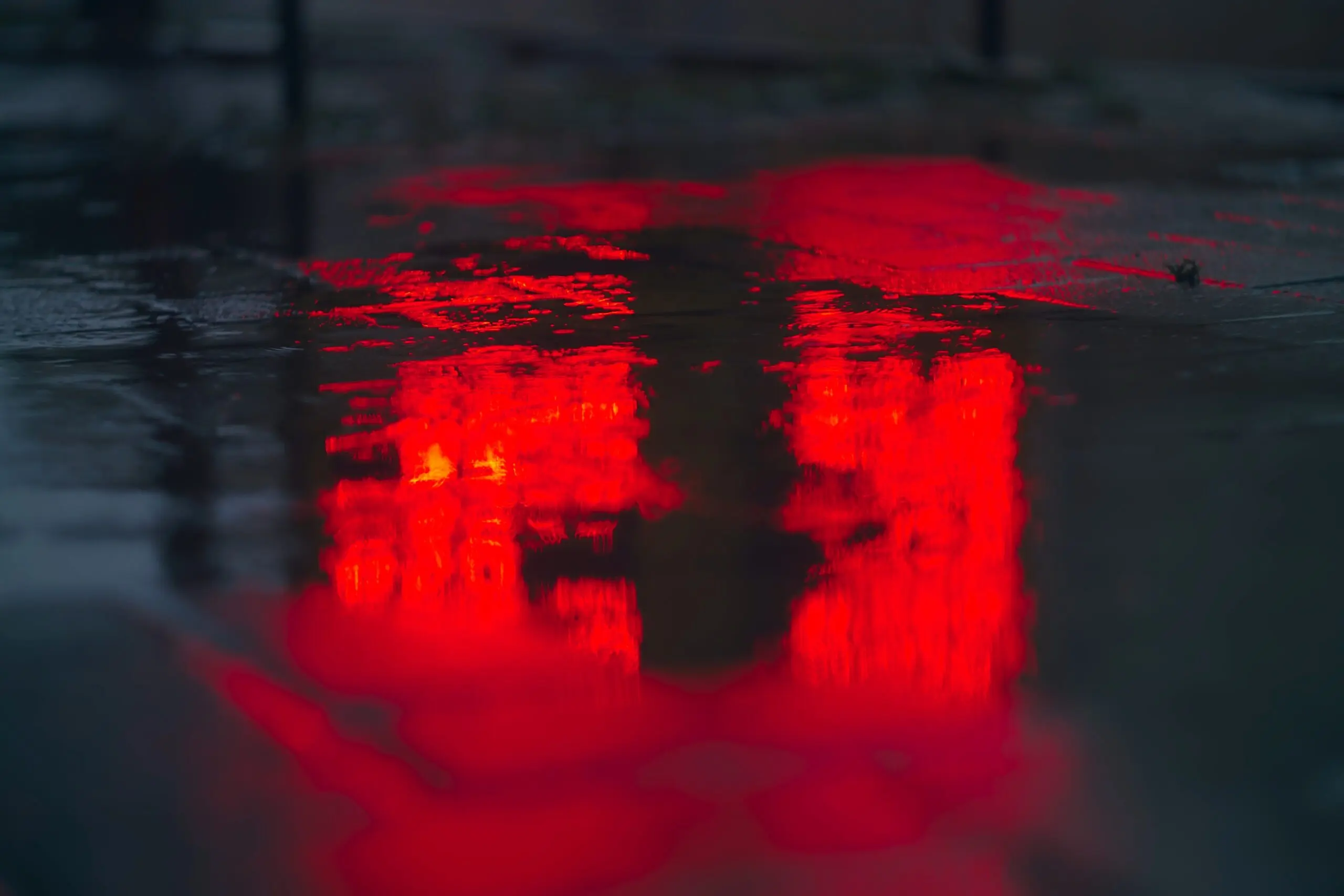 Red lights reflected in puddles
