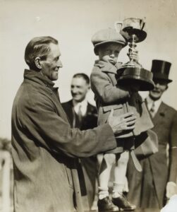 Man holding a little boy holding a trophy