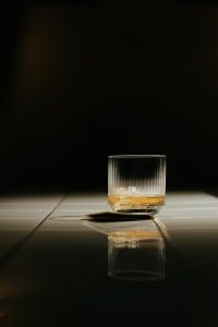clear shot glass with yellow liquid