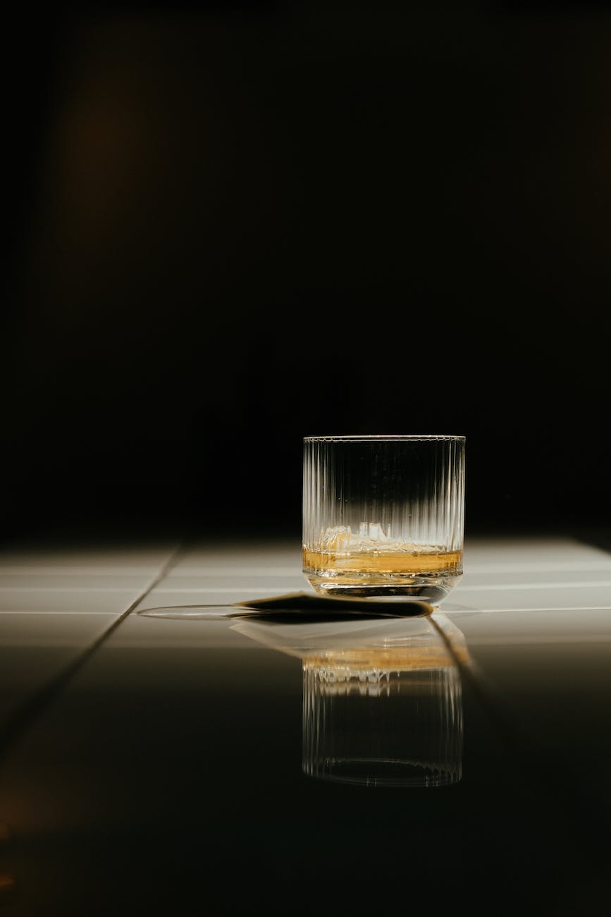 clear shot glass with yellow liquid