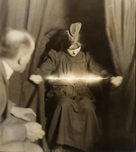 The medium Eva C. forcing a luminous apparition between her hands on May 17, 1912.