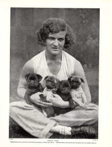 Vintage photo of a woman holding puppies.