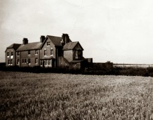 grayscale photo of house on grass field