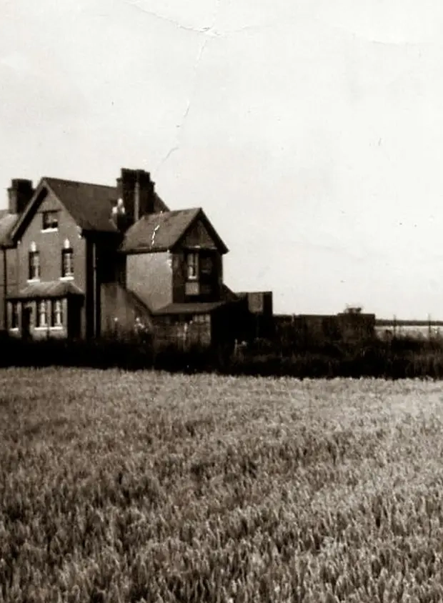 grayscale photo of a house on a grassy field