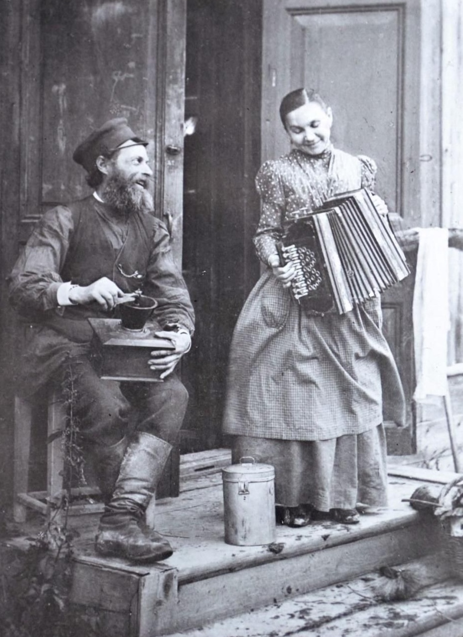 Vintage photo of a man with a coffee grinder and a woman with an accordion.