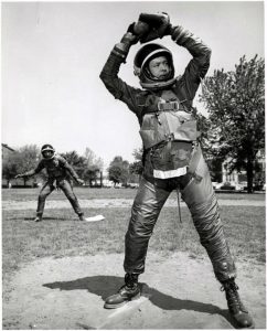 At the U.S. Naval Air Material Center in Philadelphia, a player swings a baseball bat in a B.F. Goodrich Mark IV spacesuit.