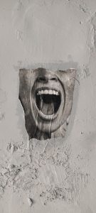 Grey mouth shouting through a wall.