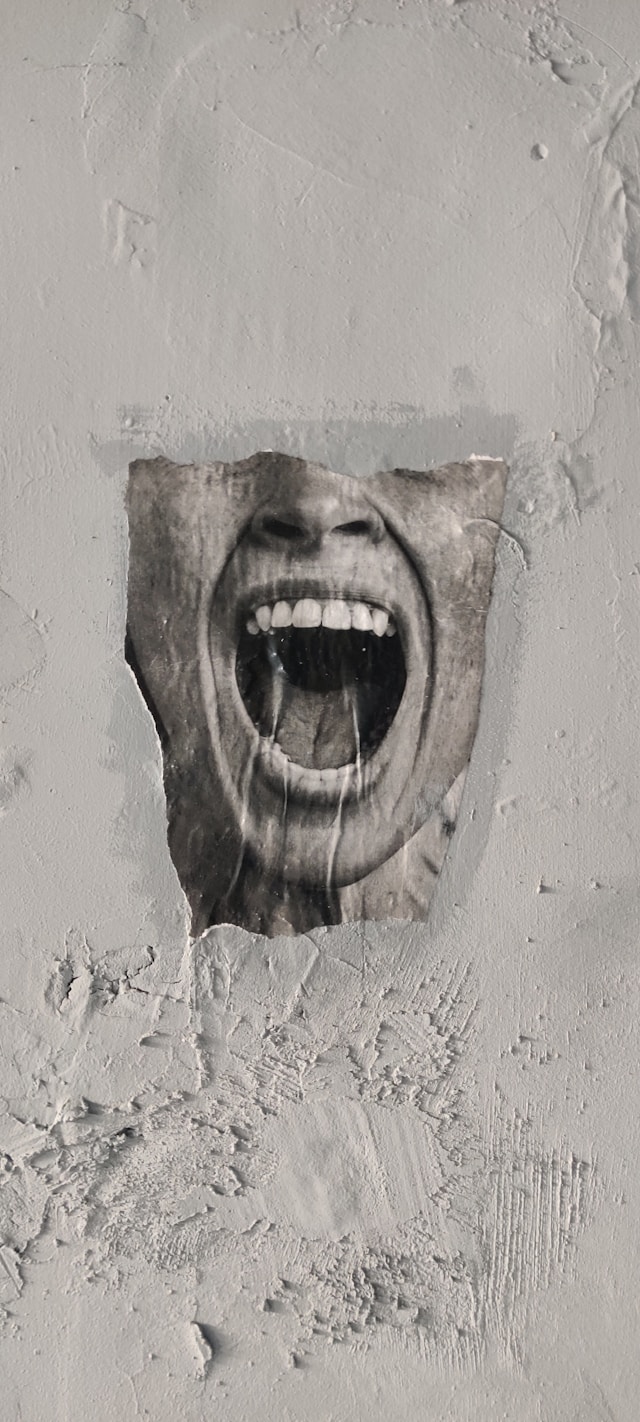 Grey mouth shouting through a wall.