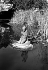 black and white photo of statue in pond